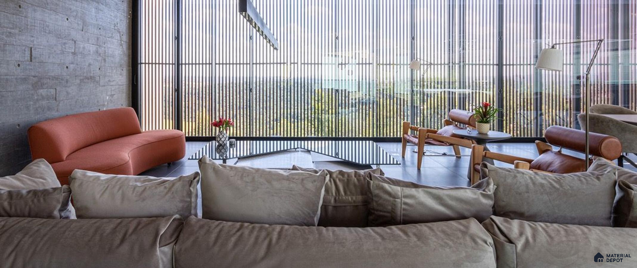 a living room filled with lots of furniture and a large windows in the center of it next to a window covered in front of a window covered in a room filled with lots of plants and bookshelves covered